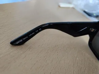 Occhiali da sole Prada neri con logo color oro.