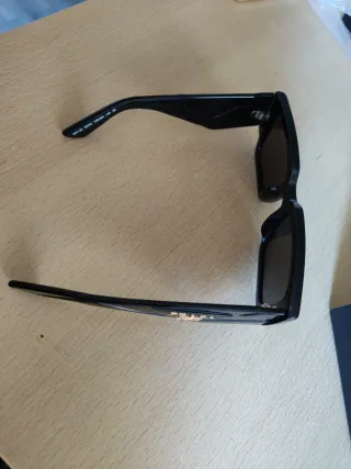 Occhiali da sole Prada neri con logo color oro.