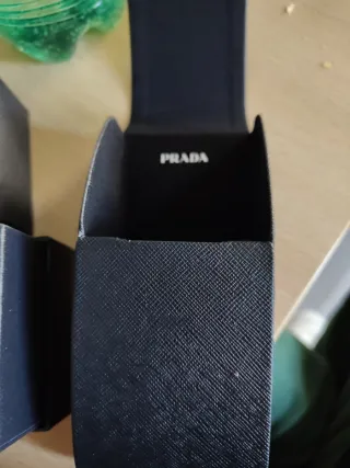 Occhiali da sole Prada neri con logo color oro.