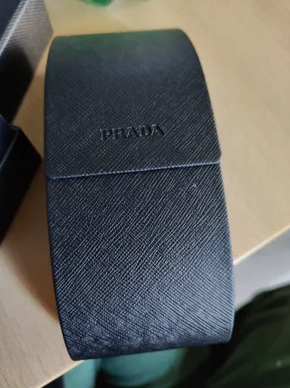 Occhiali da sole Prada neri con logo color oro.