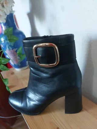 Botas negras con hebilla dorada