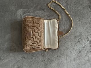 Bolso beige trenzado con cadena dorada