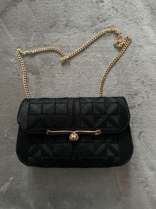 Bolso negro trenzado con cierre dorado