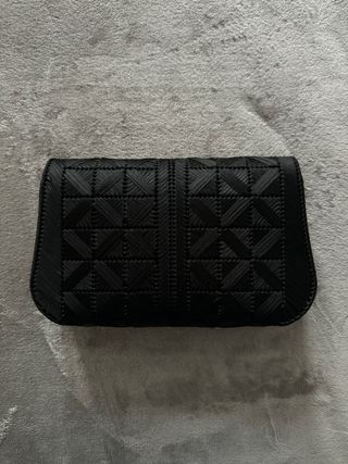 Bolso negro trenzado con cierre dorado