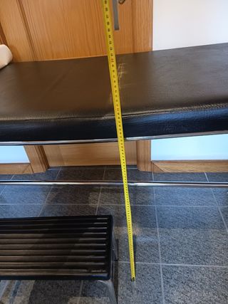 Camilla con taburete y portarrollos de papel.