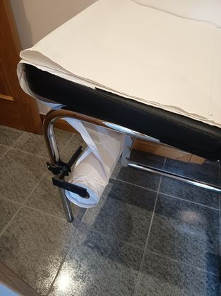 Camilla con taburete y portarrollos de papel.