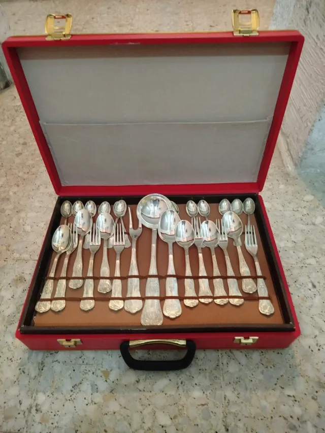 Cubertería de metal plateado en maletín rojo