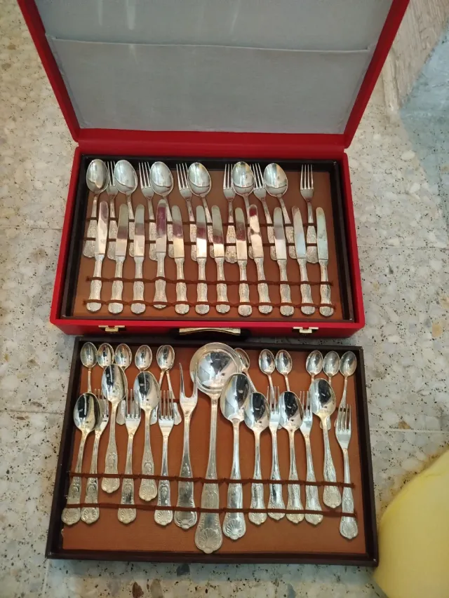 Cubertería de metal plateado en maletín rojo