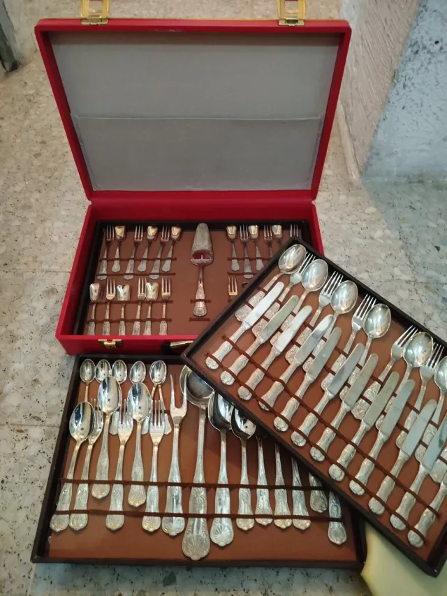 Cubertería de metal plateado en maletín rojo