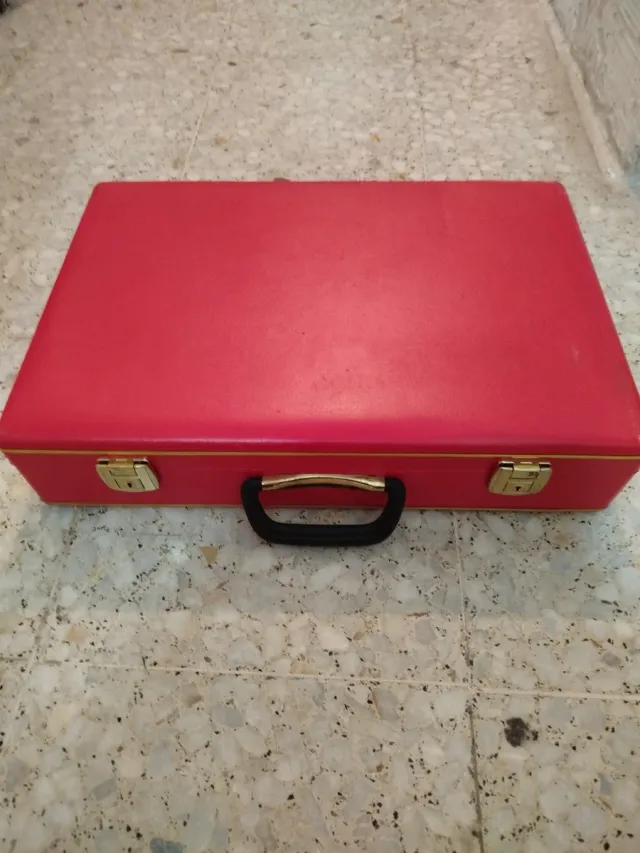 Cubertería de metal plateado en maletín rojo