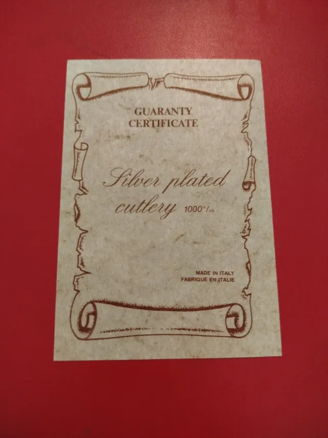 Cubertería de metal plateado en maletín rojo