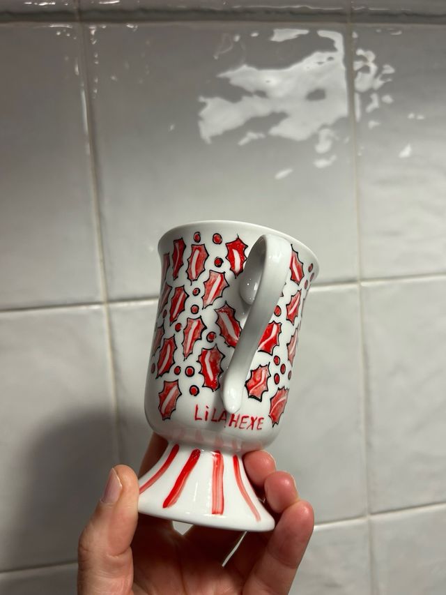 Tazza di foglie di agrifoglio rosso. porcellana