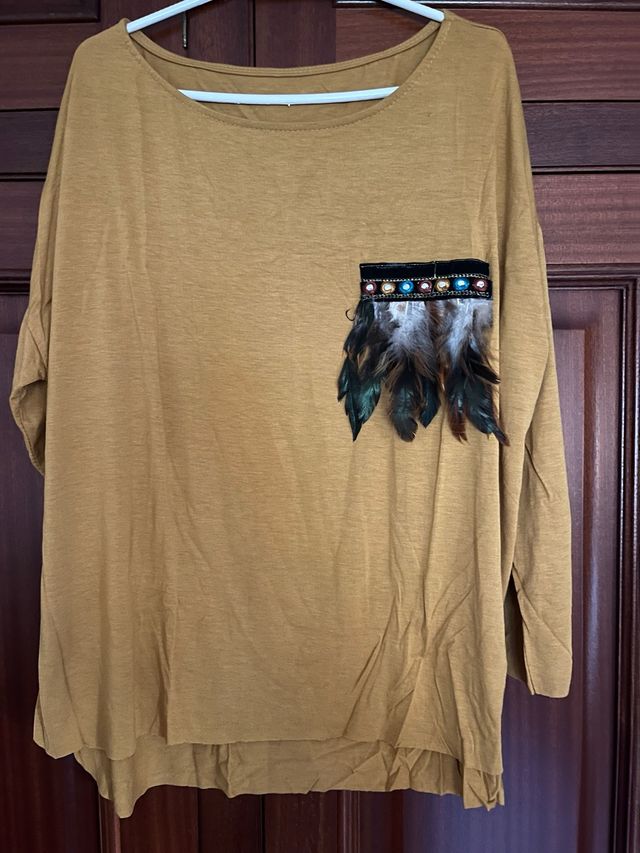 Camiseta mostaza con bolsillo estampado étnico.
