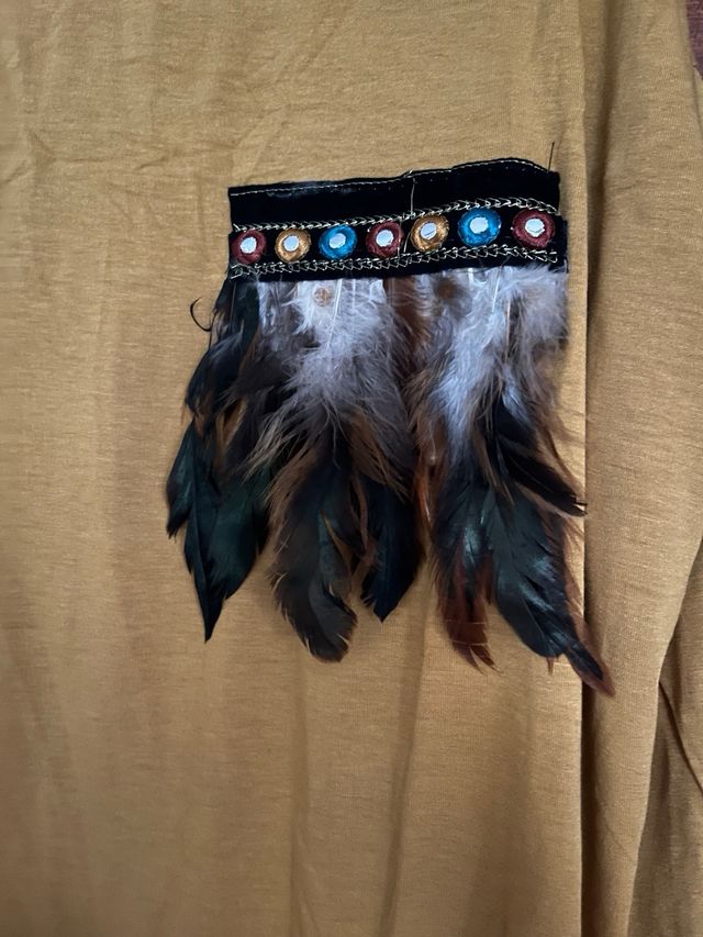 Camiseta mostaza con bolsillo estampado étnico.