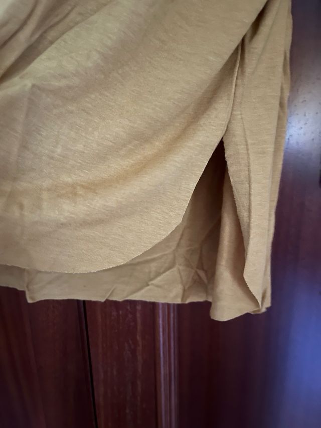 Camiseta mostaza con bolsillo estampado étnico.