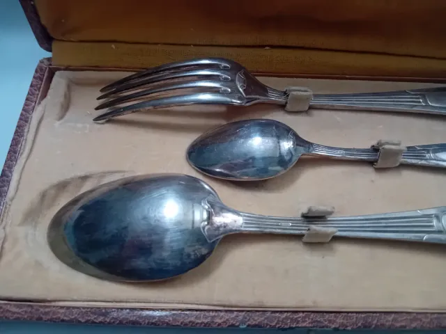 Cubiertos antiguos de metal en caja de cuero