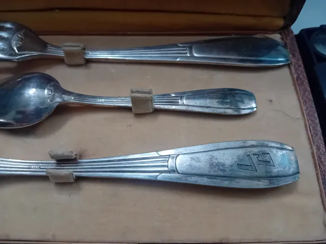 Cubiertos antiguos de metal en caja de cuero