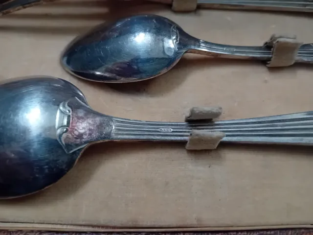 Cubiertos antiguos de metal en caja de cuero