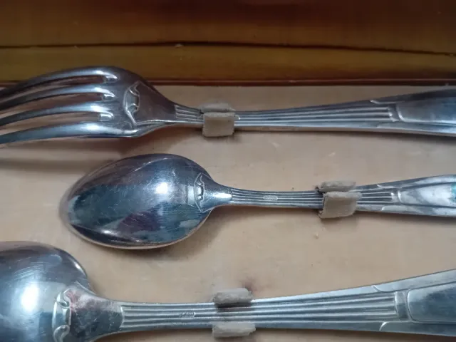 Cubiertos antiguos de metal en caja de cuero