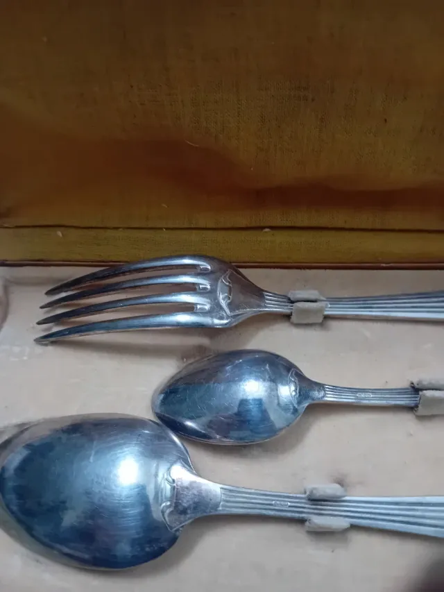 Cubiertos antiguos de metal en caja de cuero