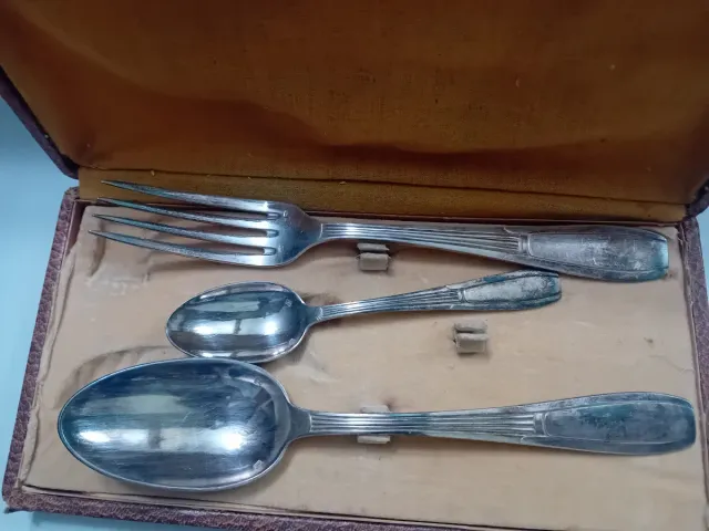 Cubiertos antiguos de metal en caja de cuero