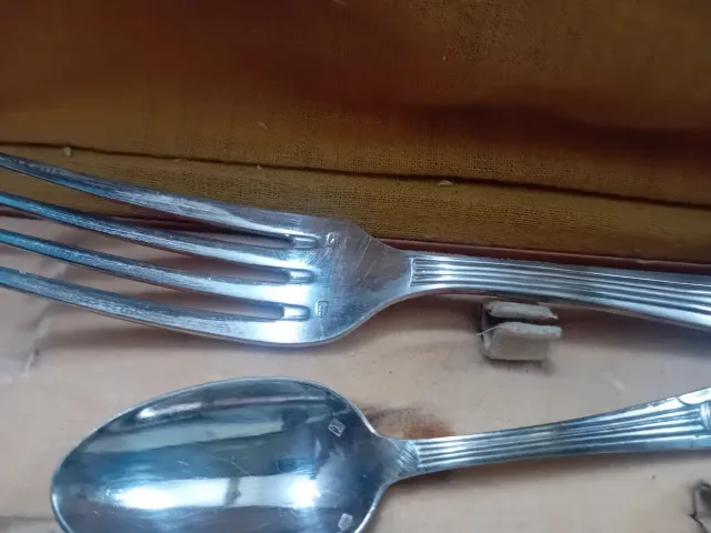 Cubiertos antiguos de metal en caja de cuero