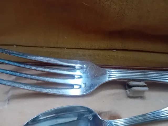 Cubiertos antiguos de metal en caja de cuero