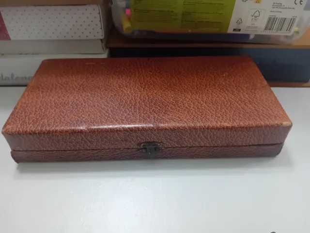 Cubiertos antiguos de metal en caja de cuero