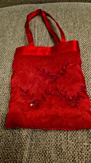 Foulard rojo con abalorios , acompañado de bolso