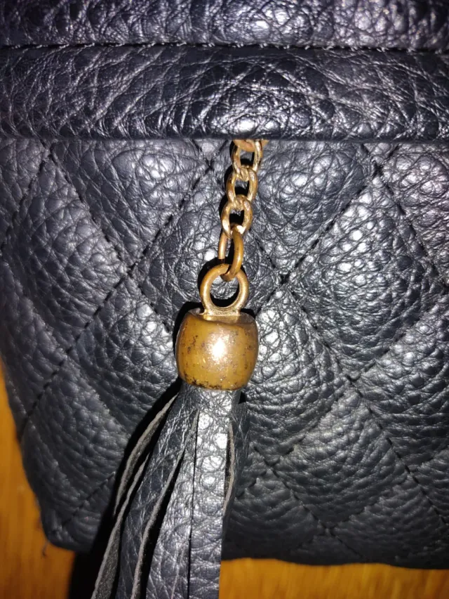 Bolso negro acolchado con flecos