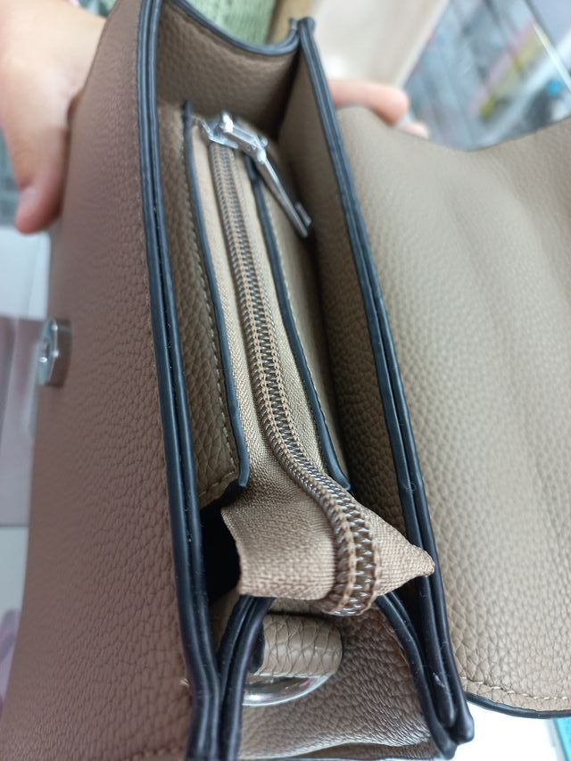 Bolso de mano beige con detalle plateado