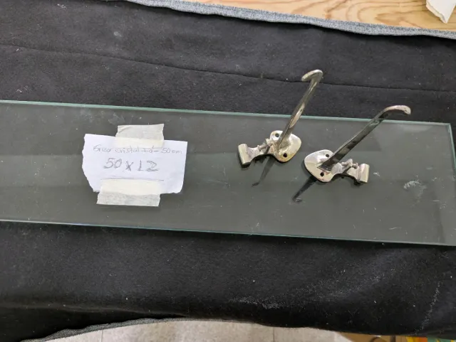 Repisa de cristal con soportes metálicos