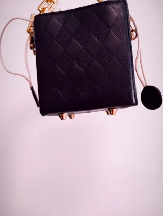 Bolso de mano negro con cadena dorada
