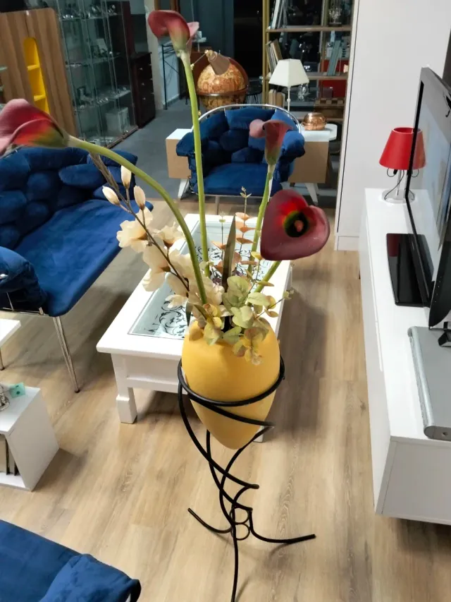 Florero decorativo con flores artificiales y más.