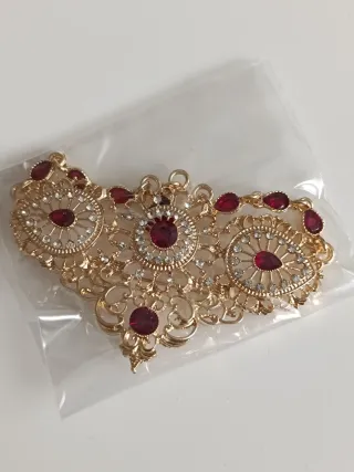 Broche dorado con piedras rojas 