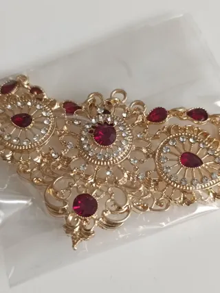 Broche dorado con piedras rojas 