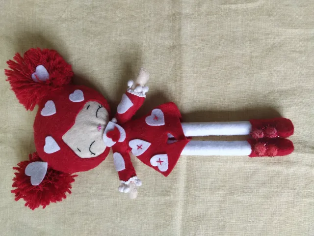 Muñeca de fieltro roja con corazones