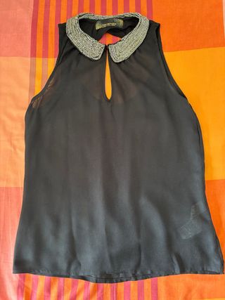 Top negro sin mangas con cuello adornado