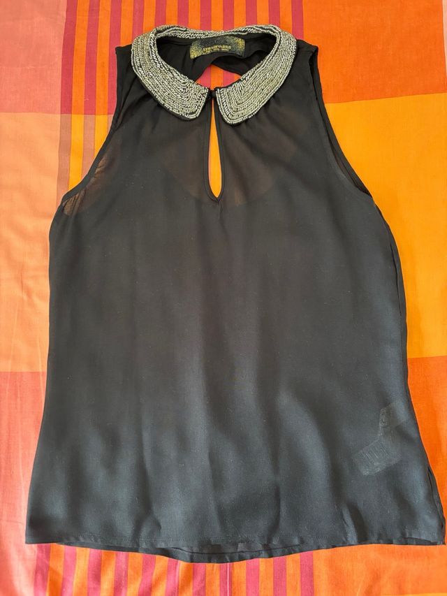 Top negro sin mangas con cuello adornado