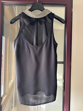 Top negro sin mangas con cuello adornado