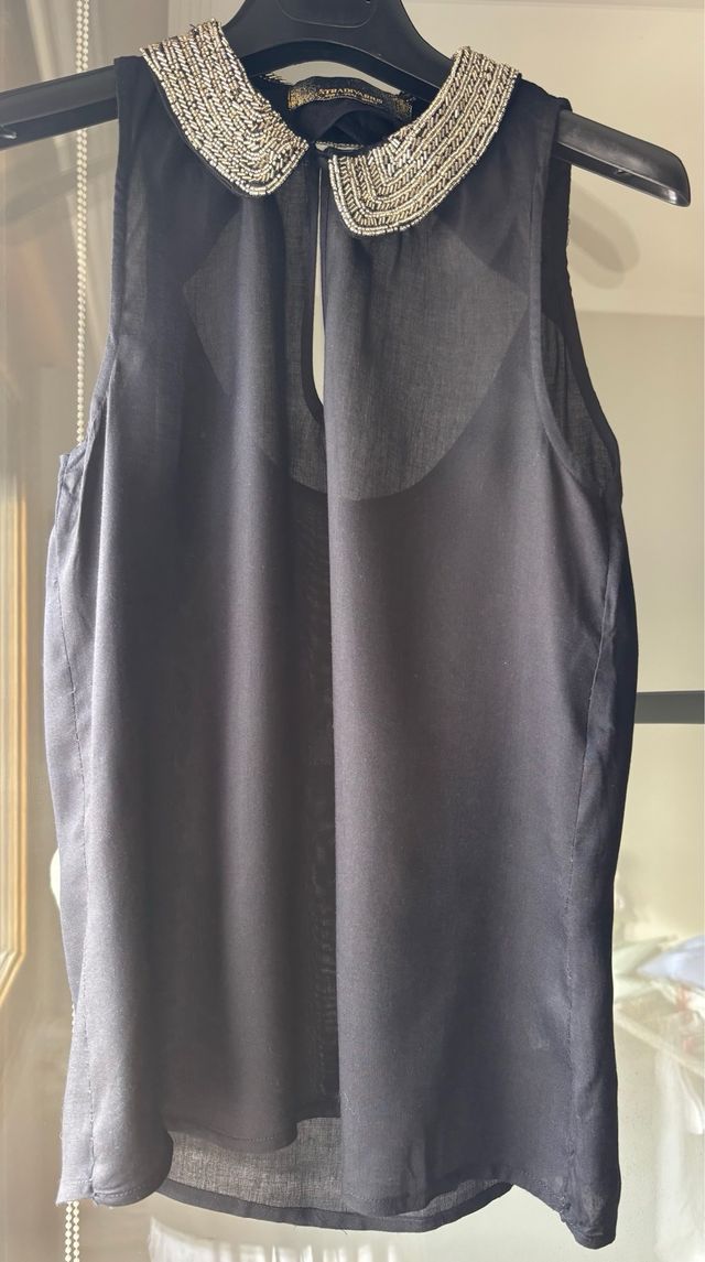 Top negro sin mangas con cuello adornado