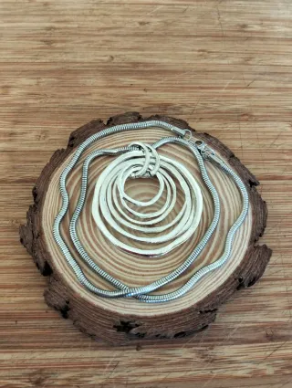 Collar largo plateado con colgante.