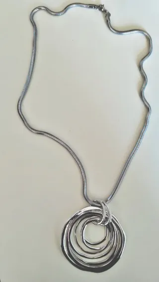 Collar largo plateado con colgante.