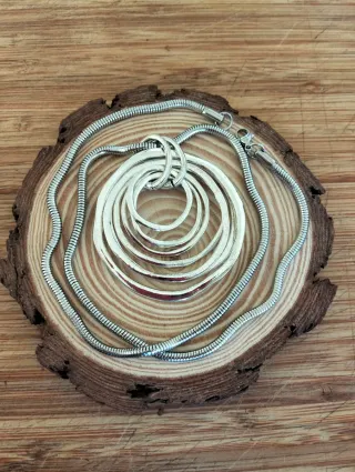 Collar largo plateado con colgante.