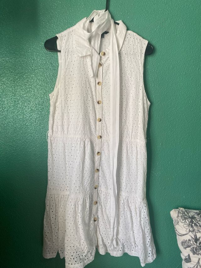 Vestido blanco con volantes, lazada y brocados