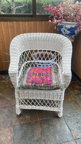 Sillón de mimbre blanco.