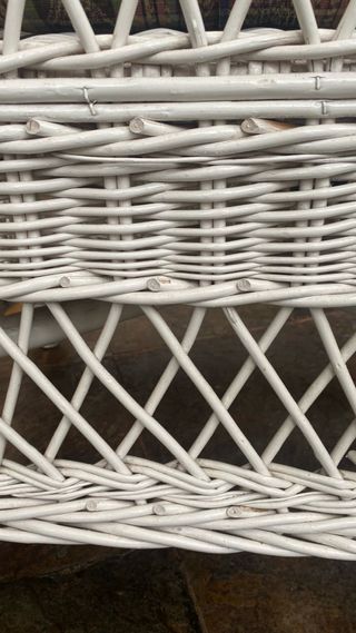 Sillón de mimbre blanco.