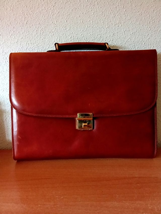 Maletín de piel en marrón y dorado.