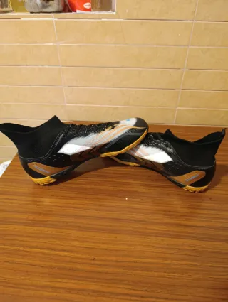 Zapatillas de fútbol negras y doradas