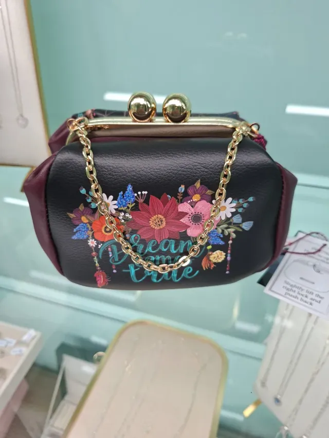 Bolso negro con flores y cadena dorada